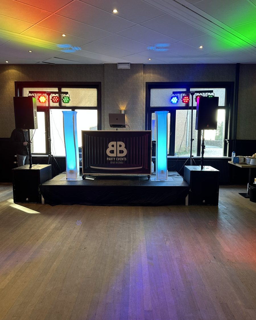 DJ-booth op podium met blauwe lichtpilaren