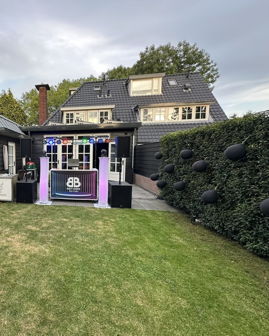 DJ-booth in tuin met paarse verlichting